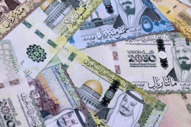 Suudi riyal para faturaları masaya yığıldı. Suudi Arabistan 'ın SAR para birimi banknotları yakın plan. Suudi Arabistan 'da iş, ekonomi ve yatırım kavramı.