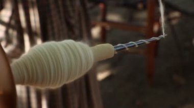 Dönen tekerleğe bağlı bir bobbin üzerinde yüksek hızda dönen ev yapımı iplik..