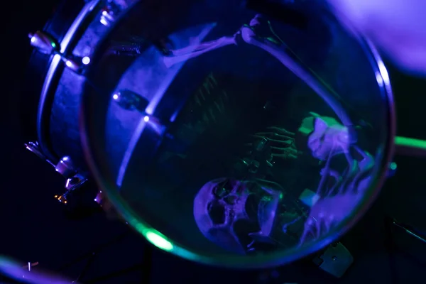 Skull reflected in drum snare blue and green lighting