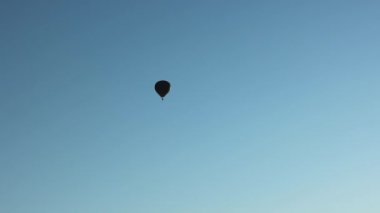 Zaman atlaması mavi gökyüzünde yüzen sıcak hava balonu.