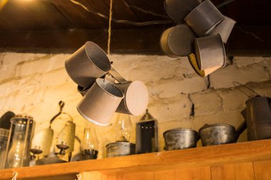 Eski bir depoda tavandan sarkan metal bardaklar.