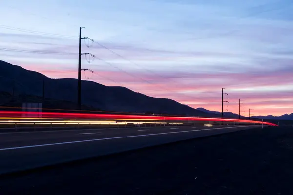 日没時に高速道路での車の交通の長い露出からの光の道 — ストック写真