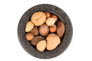 Beyaz tepeden aşağıya izole edilmiş havan topu kabuğundaki çeşitli fındık yığını.