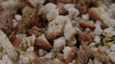 Pişmemiş ekmek parçalarını yeşil otlar ve sarı baharatlarla kaplayın.