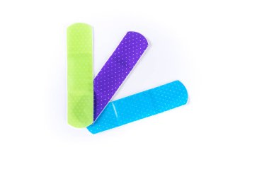 Üç renkli yapışkan bandaj şeridi üst üste biniyor.