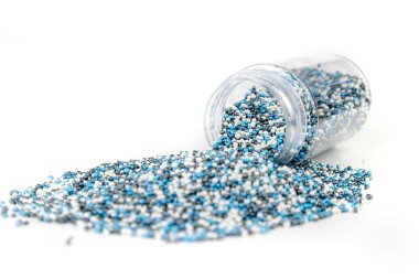 Kar renginde serpintiler, kapağı olmayan bir konteynırdan dökülüyor.