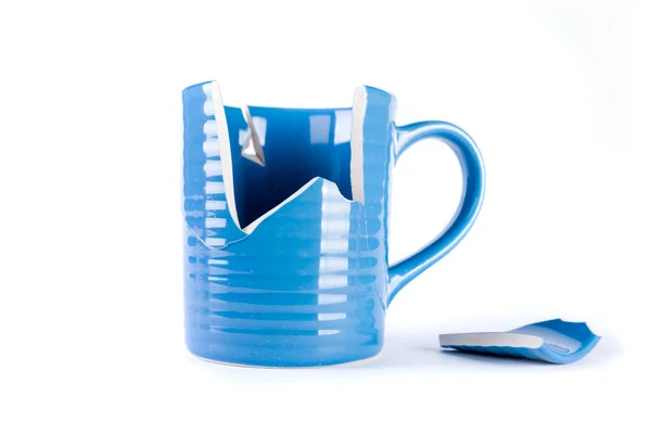 Kırık mavi kupa ve yanında kırık bir parça vardı.