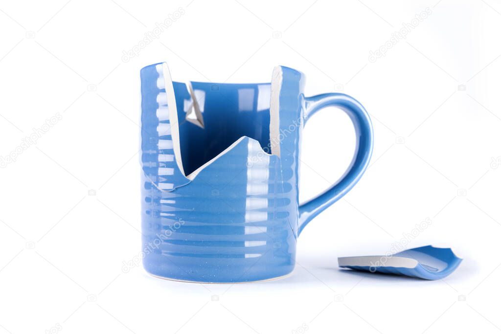 Broken blue mug with a shattered piece laying next to it