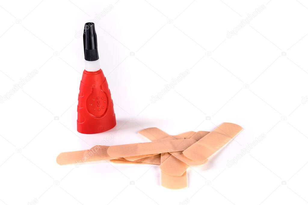 Pile of flesh colored bandages and tube of super glue