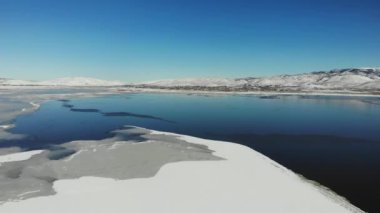 Short drone ascent over frozen lake bed in winter