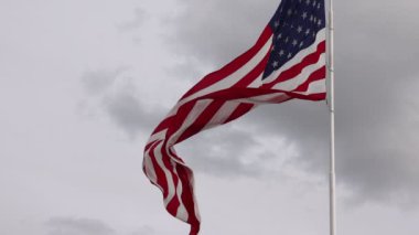 Massive american flag twisting wildly in high winds slow motion