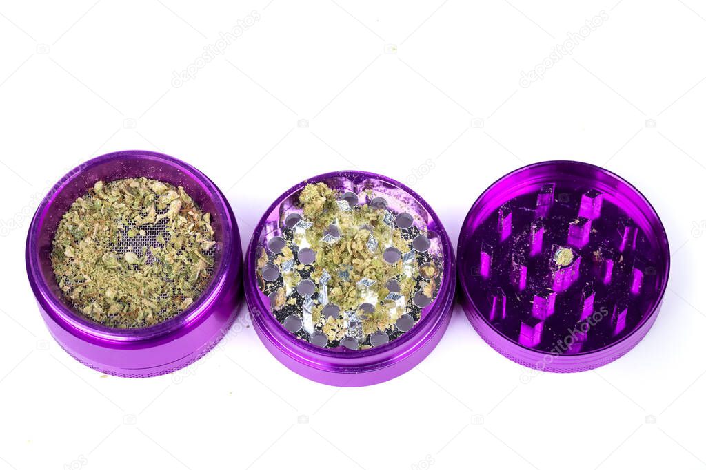 Open purple aluminum grinder with marijuana bud in various stages of process