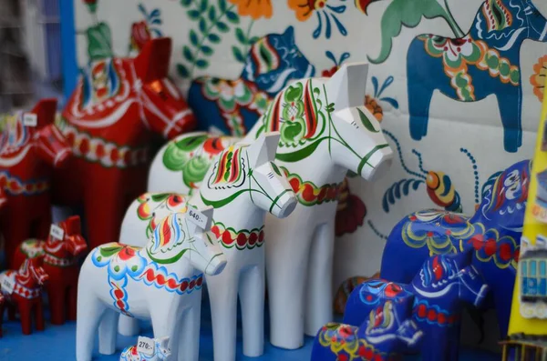 Küresel parlak bir ampulün yakın çekimi, parlak lifini karanlık bir arkaplanda sergiliyor. Şeffaf cam, karmaşık bobin dizaynını ortaya çıkararak sıcak ve çevresel bir ışık yayıyor. Ampul kısmen bir armatürle bağlantılı.