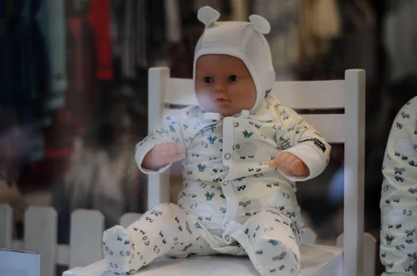 Küresel parlak bir ampulün yakın çekimi, parlak lifini karanlık bir arkaplanda sergiliyor. Şeffaf cam, karmaşık bobin dizaynını ortaya çıkararak sıcak ve çevresel bir ışık yayıyor. Ampul kısmen bir armatürle bağlantılı.