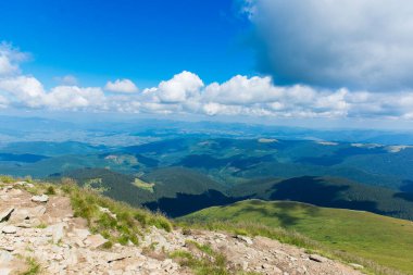 Hoverla dağından panoramik manzara yuvarlanan yeşil tepeler, derin vadiler ve Karpatya manzarası üzerinde dramatik bulutlar. Manzaralı doğa arka planı.