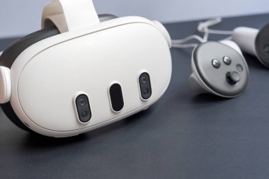 Modern VR kulaklıklar ve kumandalar karanlık masada. Fotokopi uzayı ile sanal gerçeklik oyunu ve metaçağ teknolojisi kavramı. VR ekipmanlarını kapat.