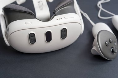 Karanlık yüzeyde VR kulaklıkları ve kontrolörlerin detaylı görüntüleri. Kopya alanı ile ilgili sanal gerçeklik oyun teknolojisi kavramı.