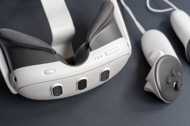 Karanlık yüzeyde VR kulaklıkları ve kontrolörlerin detaylı görüntüleri. Kopya alanı ile ilgili sanal gerçeklik oyun teknolojisi kavramı.