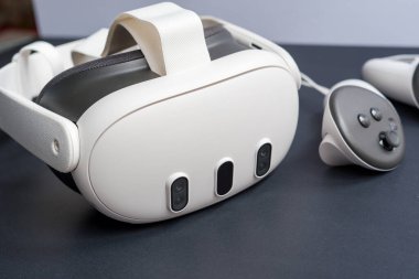 Karanlık yüzeyde VR kulaklıkları ve kontrolörlerin detaylı görüntüleri. Kopya alanı ile ilgili sanal gerçeklik oyun teknolojisi kavramı.