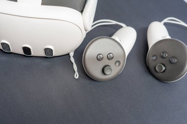 Modern VR kulaklığın ve kumandanın yakın plan görüntüleri. Sanal gerçeklik oyunları, metaevren ve büyüleyici teknoloji kavramı. Boşluğu kopyala.