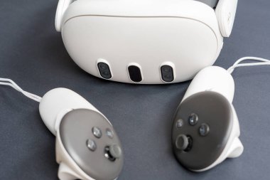 Karanlık yüzeyde VR kulaklıkları ve kontrolörlerin detaylı görüntüleri. Kopya alanı ile ilgili sanal gerçeklik oyun teknolojisi kavramı.