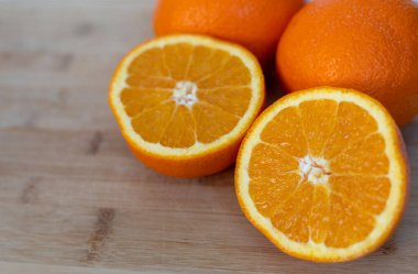 Tahta kesme tahtasındaki portakallı taze portakalı kapat. C vitamini ve sağlıklı beslenme açısından zengin sulu narenciye meyvesi..