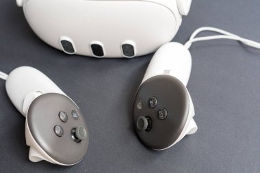 Siyah arka planda kulaklığı olan sanal gerçeklik kontrolörlerine yakın çekim. Oyun kavramı, dolambaçlı teknoloji ve modern dijital cihazlar.