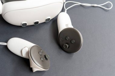 Siyah arka planda kulaklığı olan sanal gerçeklik kontrolörlerine yakın çekim. Oyun kavramı, dolambaçlı teknoloji ve modern dijital cihazlar.