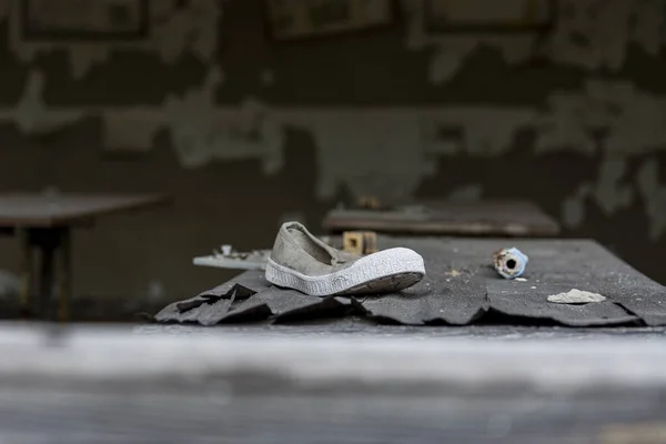 Una zapatilla de deporte en el escritorio de una escuela abandonada en la zona de exclusión de Chernobyl —  Fotos de Stock