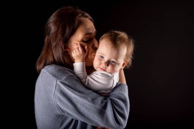 Siyah arka planda sevimli ve mutlu kızı olan güzel bir anne..