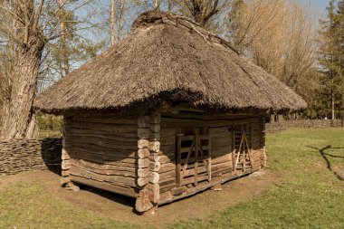 Kırsal bir ev duvarı, mavi ahşap panelli ve sarı oymalı bir platform bandı olan bir pencere.