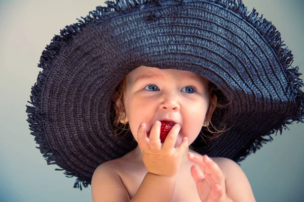 Piccola ragazza carina in un cappello da spiaggia nero con ala larga — Foto Stock