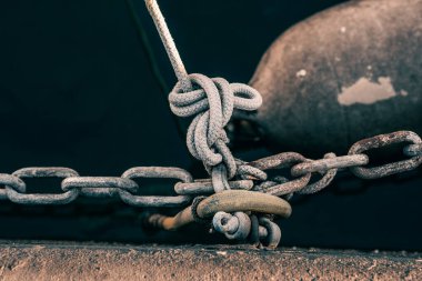 Zincirler ve ipler, bir marinanın beton setine gömülmüş metal halkalara bağlıdır. Bağlanma zinciri, halatlar, düğümler ve demirleme gemileri gergin, rıhtıma giden tekneler, yatlar ve motorlu tekneler var..