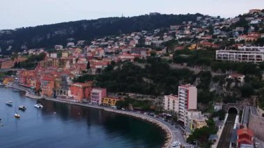 Fransa 'nın Villefranche-sur-Mer kentinin hava panoramik 4K videosu, rıhtım, sahil, demiryolu, tarihi evler ve körfezde lüks yatlar yer alıyor. Fransız Rivierası 'ndaki Villefranche-sur-Mer' in çarpıcı drone görüntüsü.