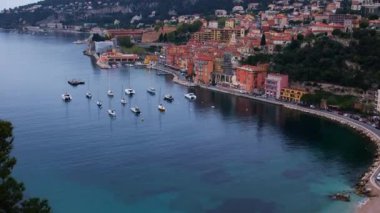 Fransa 'nın Villefranche-sur-Mer kentinin hava panoramik 4K videosu, rıhtım, sahil, demiryolu, tarihi evler ve körfezde lüks yatlar yer alıyor. Fransız Rivierası 'ndaki Villefranche-sur-Mer' in çarpıcı drone görüntüsü.