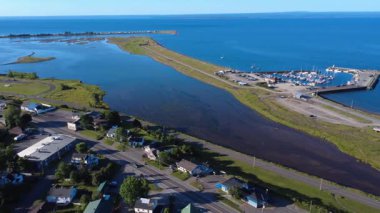 Küçük bir marina ve teknelerinin deniz manzarası. Kum ve otlardan oluşan bir kıyı şeridinde yer alan ve efsanevi Baie des Chaleurs, Carleton-sur-Mer, Quebec, Kanada, 2025 'e bakan bir tuz bataklığı oluşturuyor..