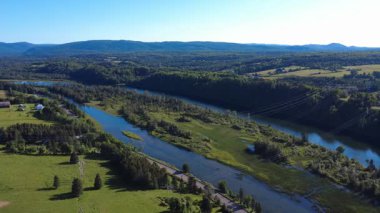 Cascapedia Nehri 'ni geçen üç elektrik nakil hattı, bu noktada iki dala ayrılan bir somon balıkçı nehri. Gasp Yarımadası, Quebec, Kanada, 2025.