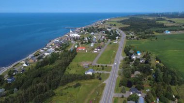 Baie-des-Sables 'ın kıyı köyünün ve Gasp kıyısındaki görkemli St. Lawrence nehri kıyısındaki kilisesinin havadan görünüşü 132 numaralı turist güzergahı, Quebec, Kanada, 2025.