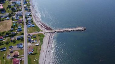 Eski terk edilmiş bir rıhtımın havadan görünüşü Saint Lawrence Nehri 'nin sakin sularına, Quebec, Kanada, 2025' teki Baie-des-Sables sahil köyünün kumlu sahilinden giriyor..