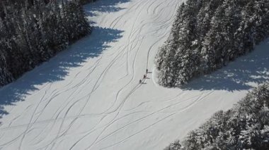 Kayak meraklılarından oluşan bir üçlünün tek sıra halinde dik bir yamaca tırmanması ve yeni karla kaplı ormanda zigzag çizmesi. Mont-Castor, Matane, Quebec, Kanada.