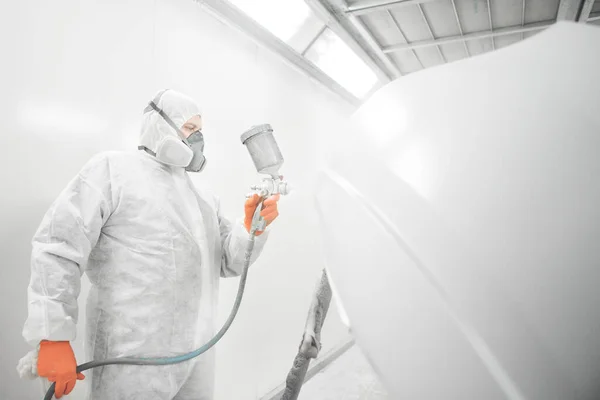 Trabajador pulverización de pintura blanca con pistola de pulverización en el coche. — Foto de Stock