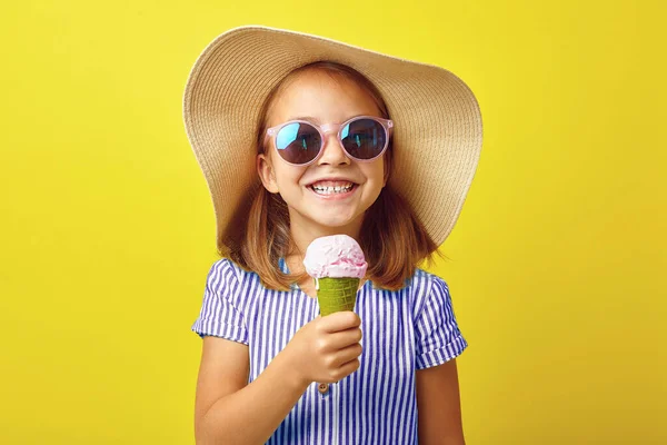 노란 배경에 아이스크림을 갖고 있는 쾌활 한 어린 소녀. — 스톡 사진