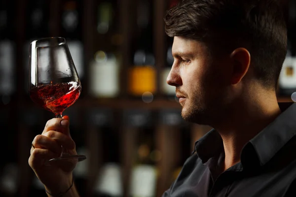 Bokal Rotwein im Hintergrund, männlicher Sommelier schätzt Getränk — Stockfoto