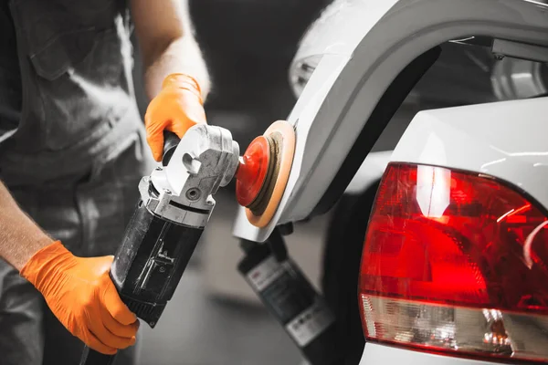 Série detalhando do carro: polimento do veículo branco na oficina de reparação automóvel. Fotografia De Stock