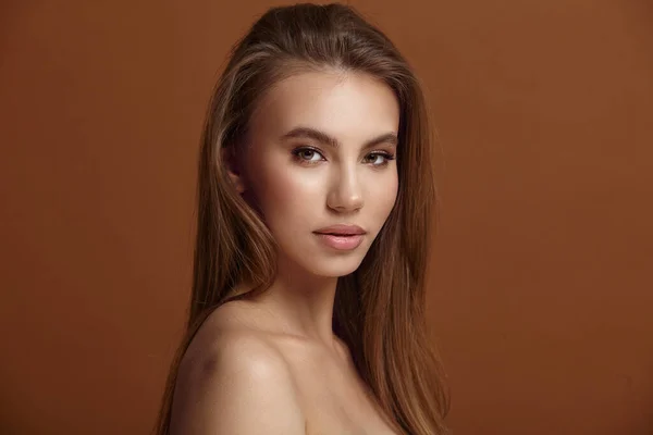 Seductive young woman with bare shoulders at brown wall Stock Image