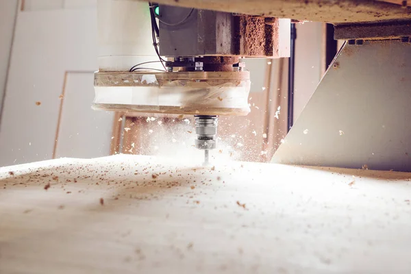 Cnc machine at carpentry workshop. Cutting wood with various router bits. Stock Picture