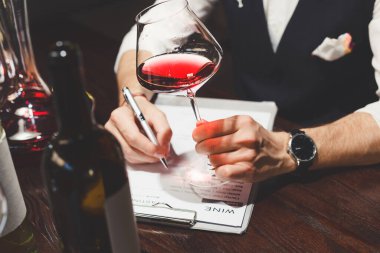 Sommelier panoya kırmızı şarabı tanımlayan bir yazı yazmış.