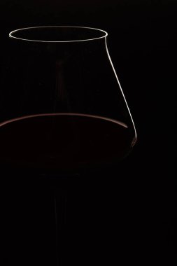 Siyah arka planda beyaz ve kırmızı şarap kasesi silueti. Zarif şeffaf şarap kadehleri ve pembe veya gül alkollü içecekler karanlıkta görülebilir. - Yakın çekim. Uzayı kopyala Yan görünüm.