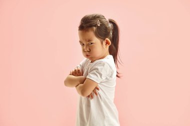 Huysuz Koreli görünüşünün stüdyo portresi. Yüzü gücenmiş küçük bir kız. Bir şeyden memnun kalmamış, öfkeyle iç çekiyor. Hoşnutsuzluk ve