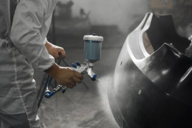 Arabanın sprey boyasıyla boyanmadan önce astar boya uygulaması. Kazadan sonra aracın onarımı ve restorasyonu.